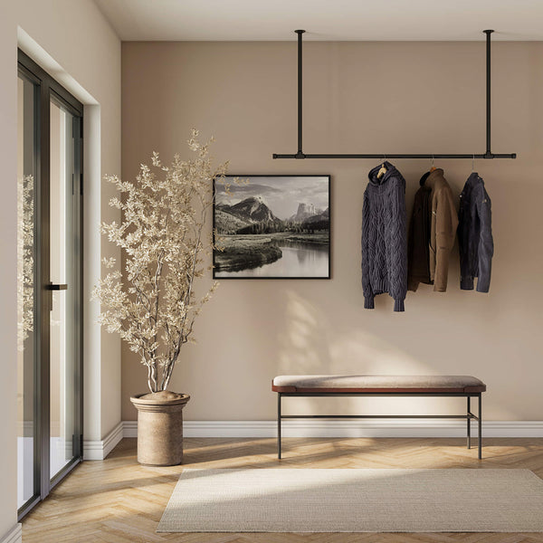 Deckenmontierte Kleiderstange aus schwarzen Eisenrohren im industriellen Design für minimalistische Lösung im Eingang